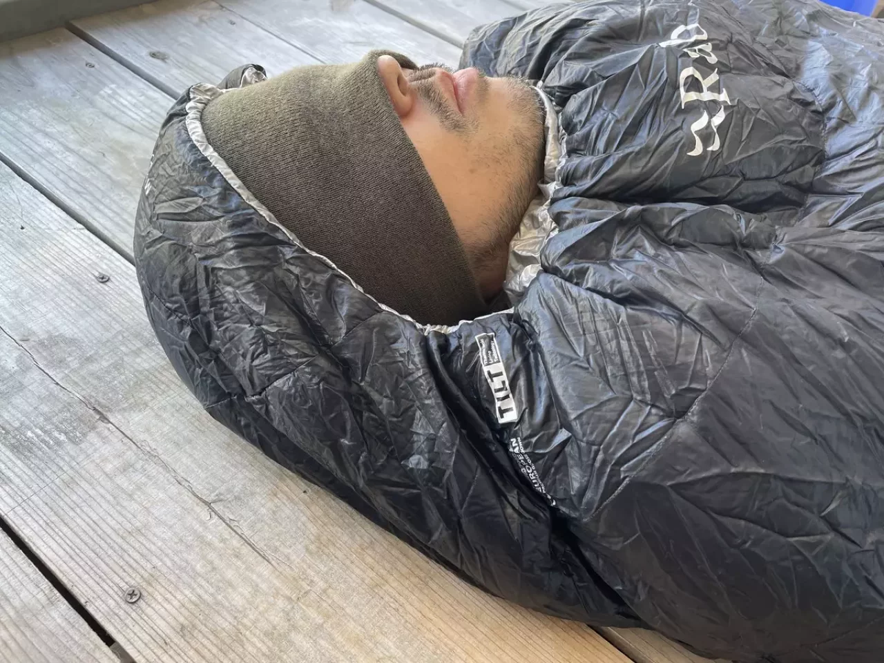 ニット帽を深くかぶることで目を隠し就寝する