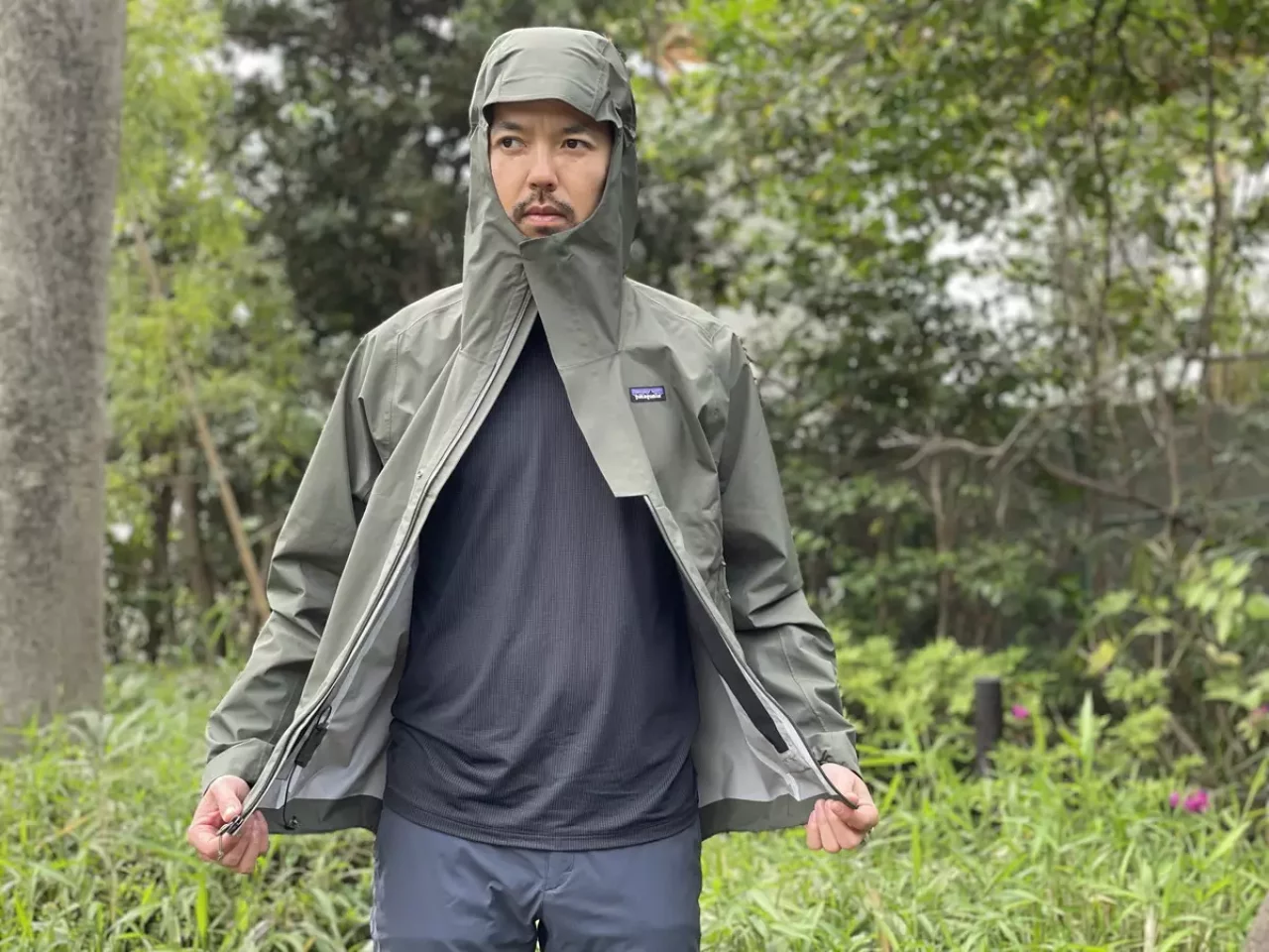レインジャケットの袖に手を通さず、上のスナップボタンのみ留めて行動