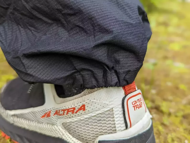 裾のかかと側には伸縮性の高いゴムが内蔵 Rabの軽量レインパンツ