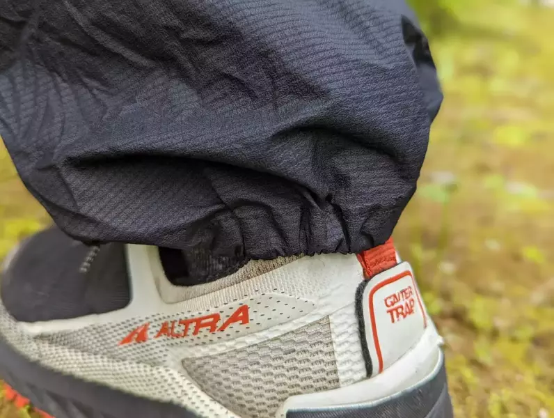 裾のかかと側には伸縮性の高いゴムが内蔵 Rabの軽量レインパンツ