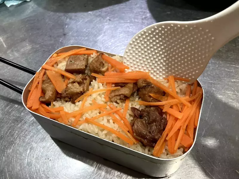 炊き込みご飯をしゃもじで軽く混ぜる