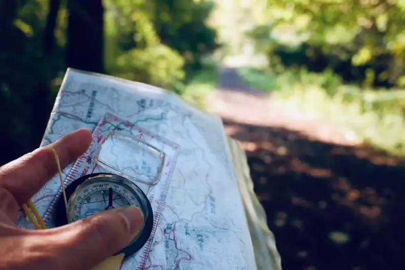 道迷い遭難/方位磁針で方角を確認するハイカー