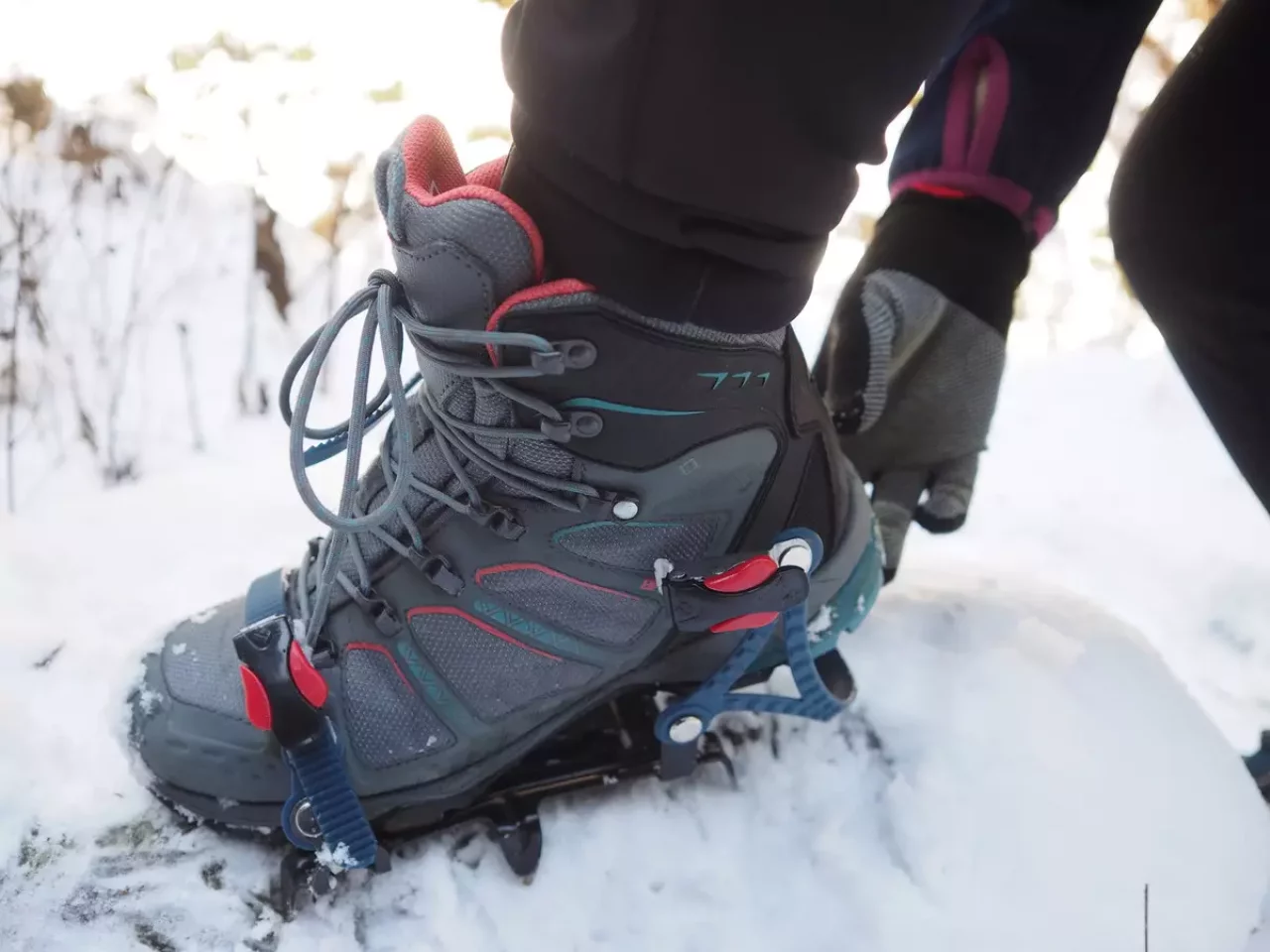登山靴にアイゼンを着ける女性
