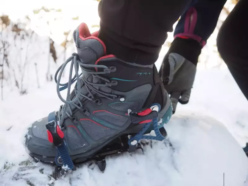 登山靴にアイゼンを着ける女性